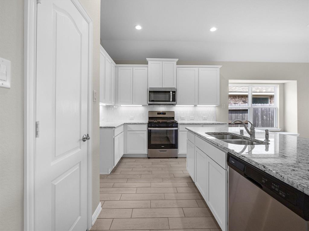 A kitchen with white cabinets.