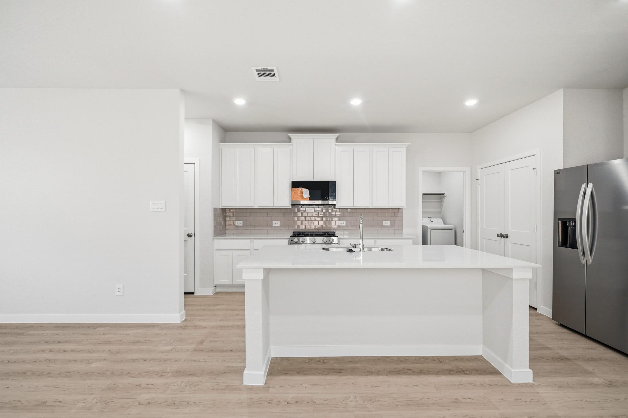 A kitchen with white cabinets.