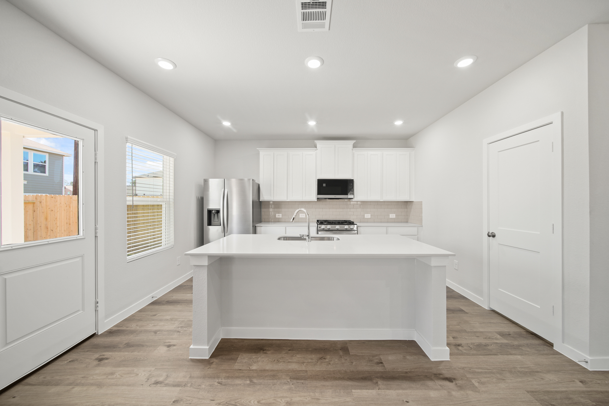 A kitchen with white cabinets.
