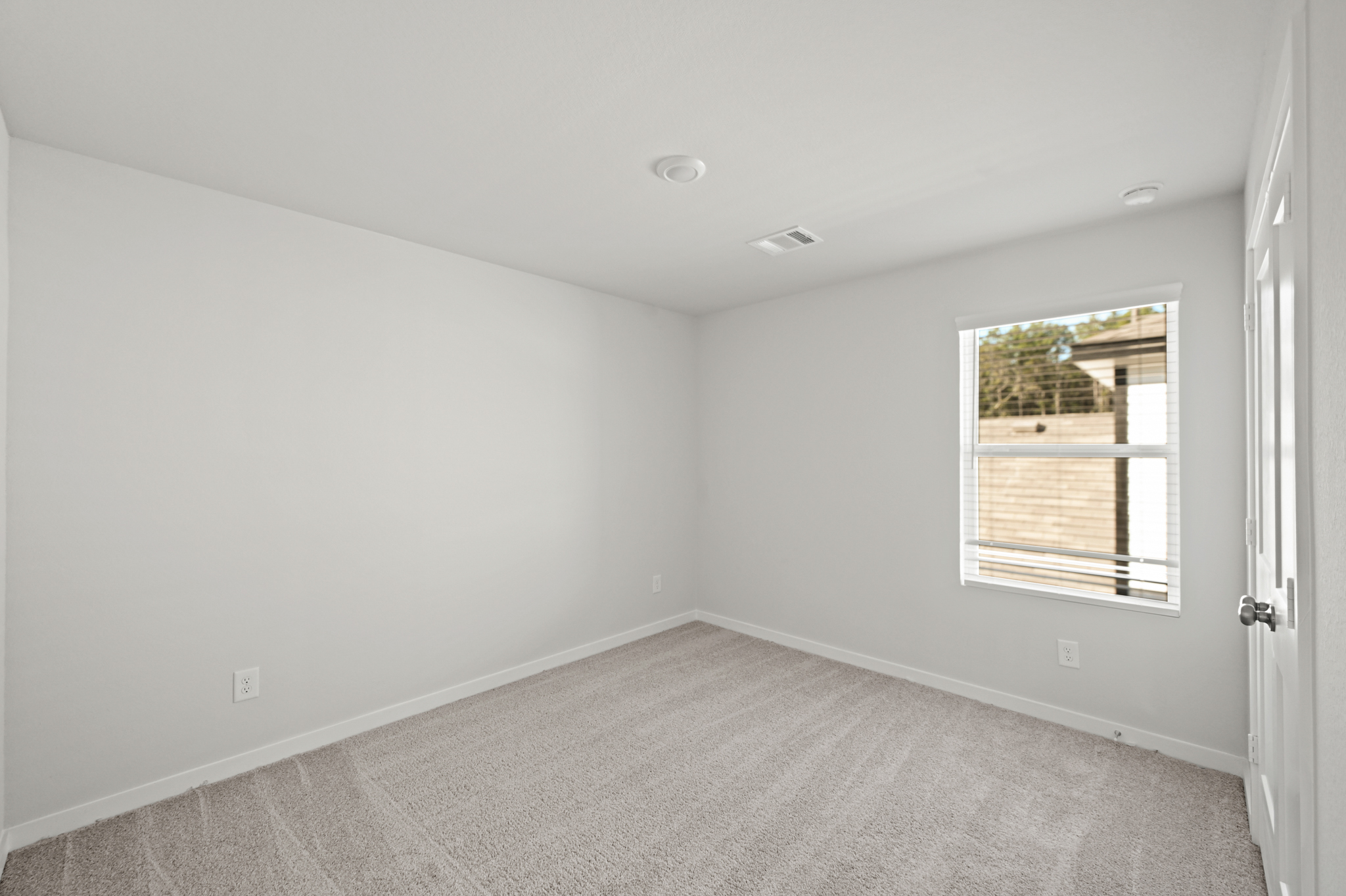 A room with a window and a carpet.