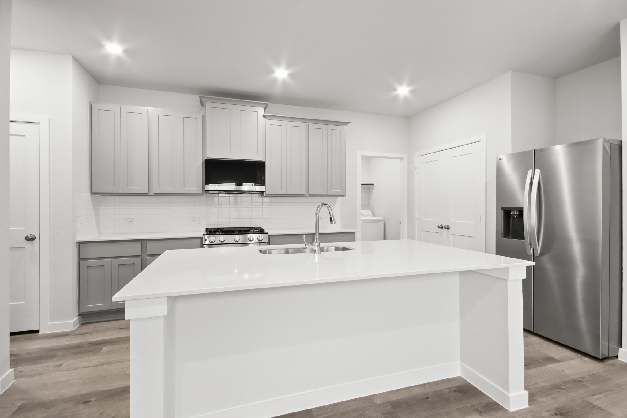 A kitchen with white cabinets.