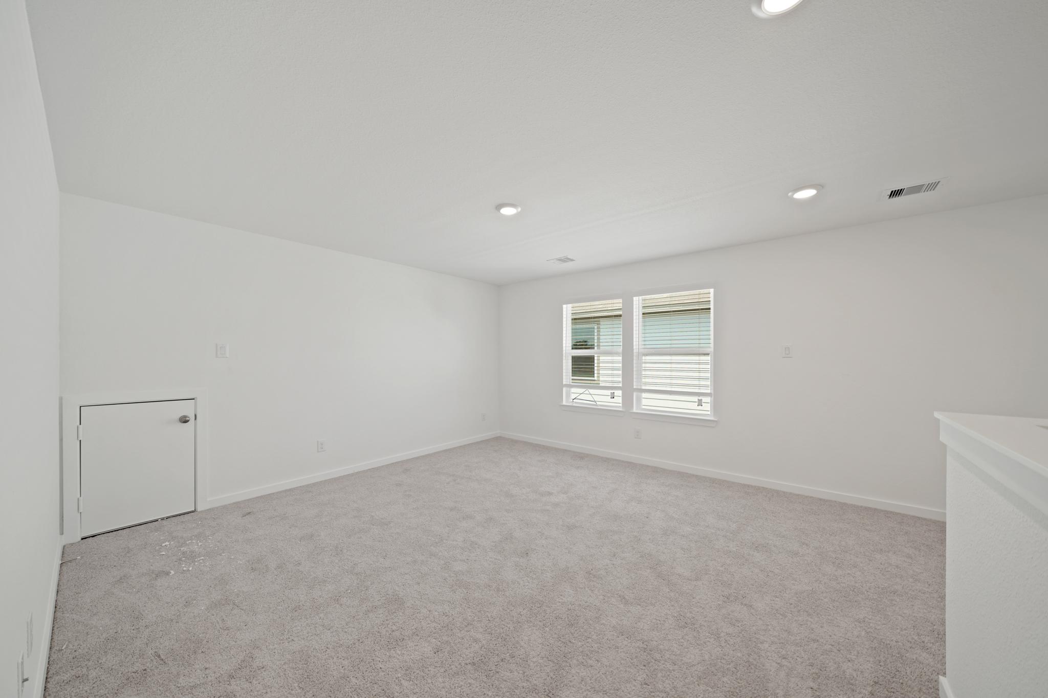 A room with a white wall and windows.