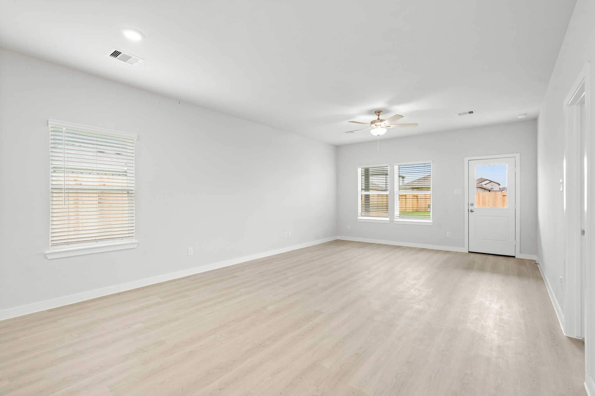 A room with a wood floor and a ceiling fan.