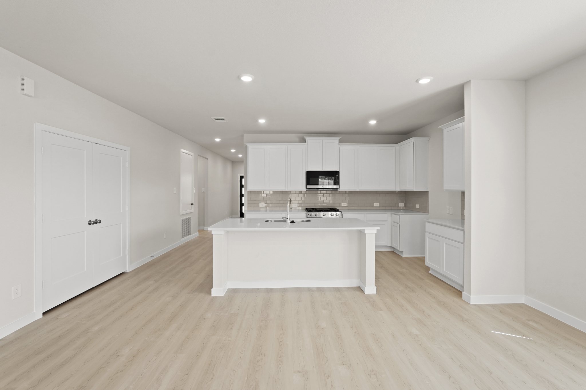 A kitchen with white cabinets.