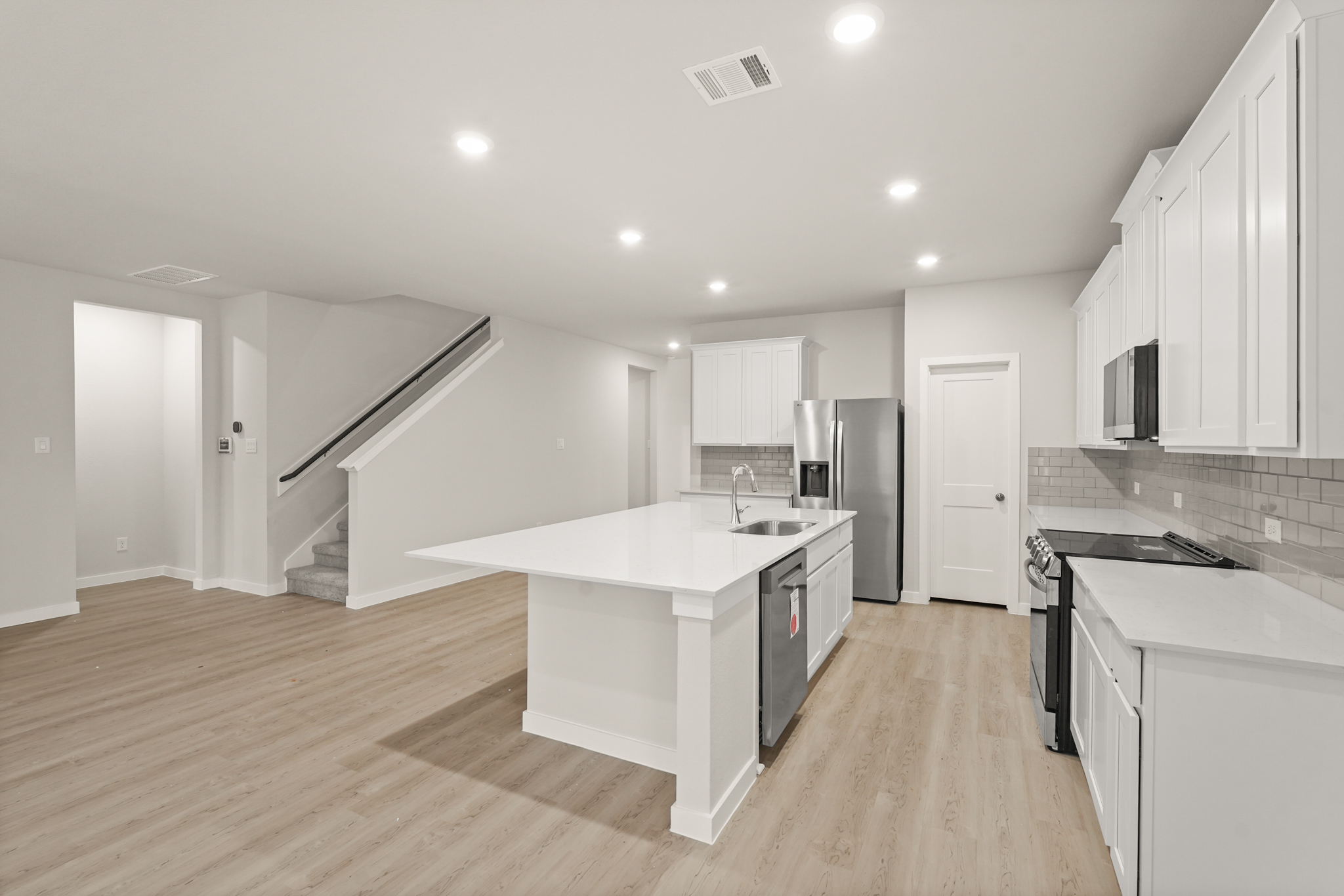 A kitchen with white cabinets.