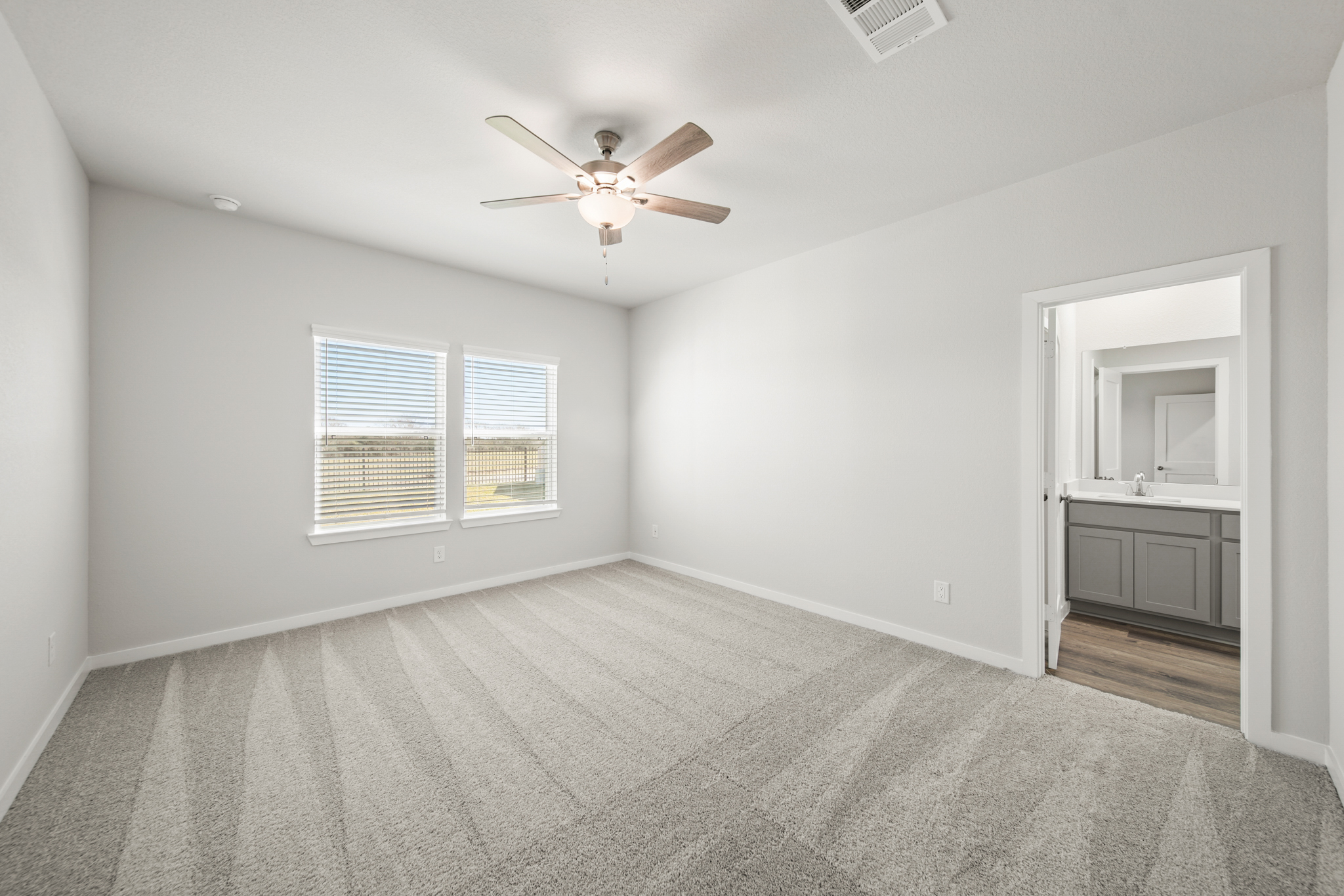 A room with a ceiling fan and a window.