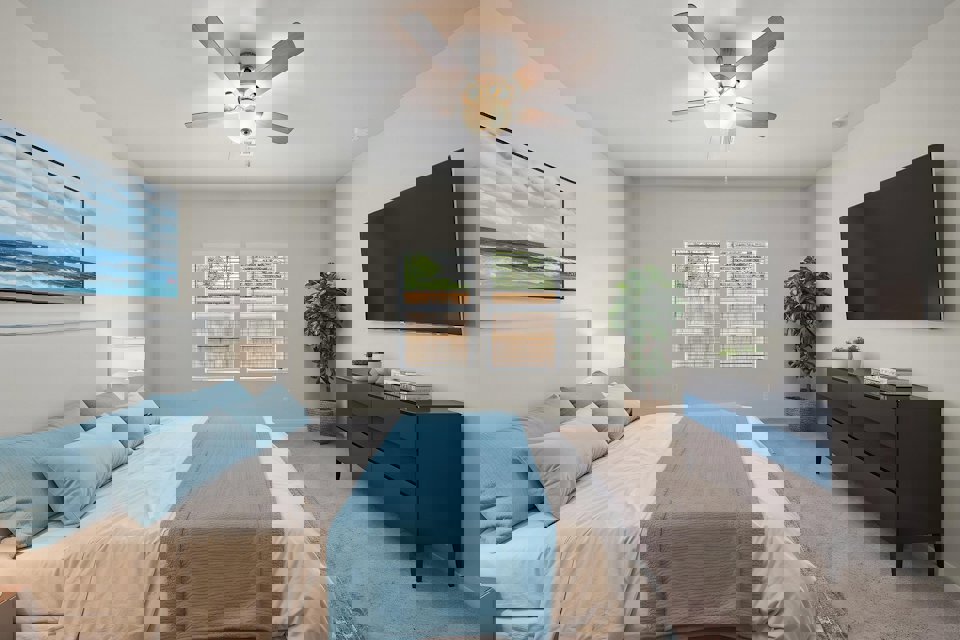 A bedroom with a bed and a fan.