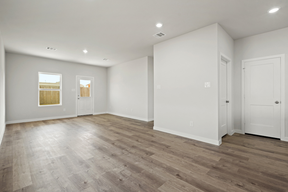 A room with white walls and wood floors.