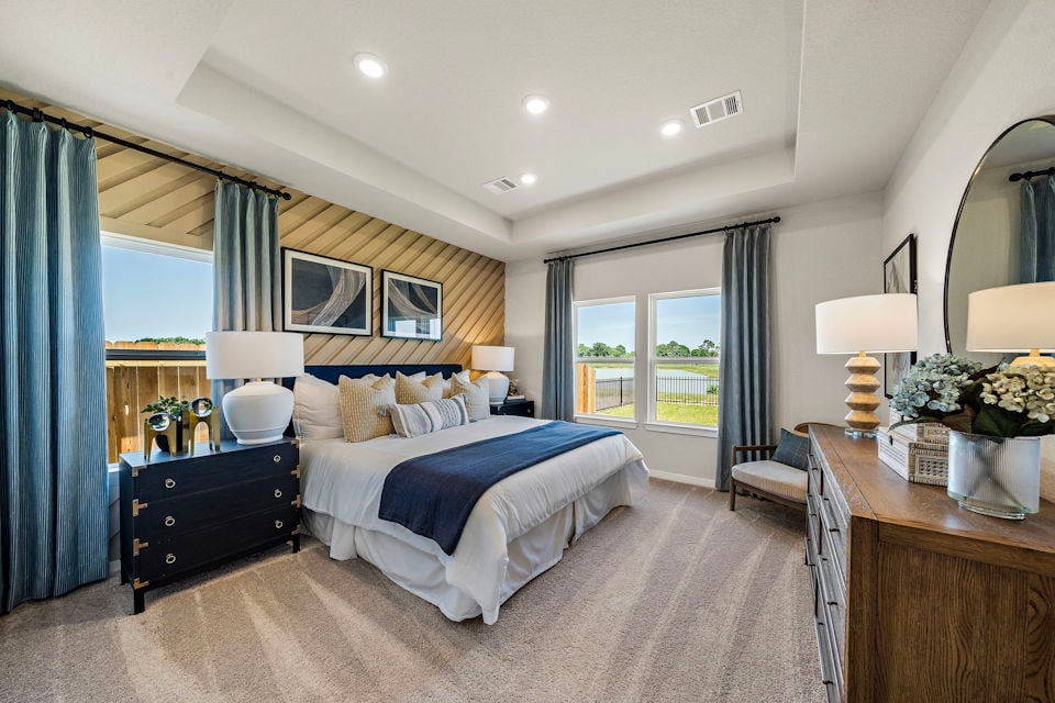 A bedroom with a large mirror.