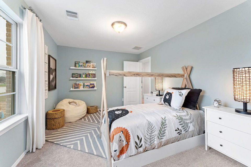 A bedroom with a bed and a shelf with books.