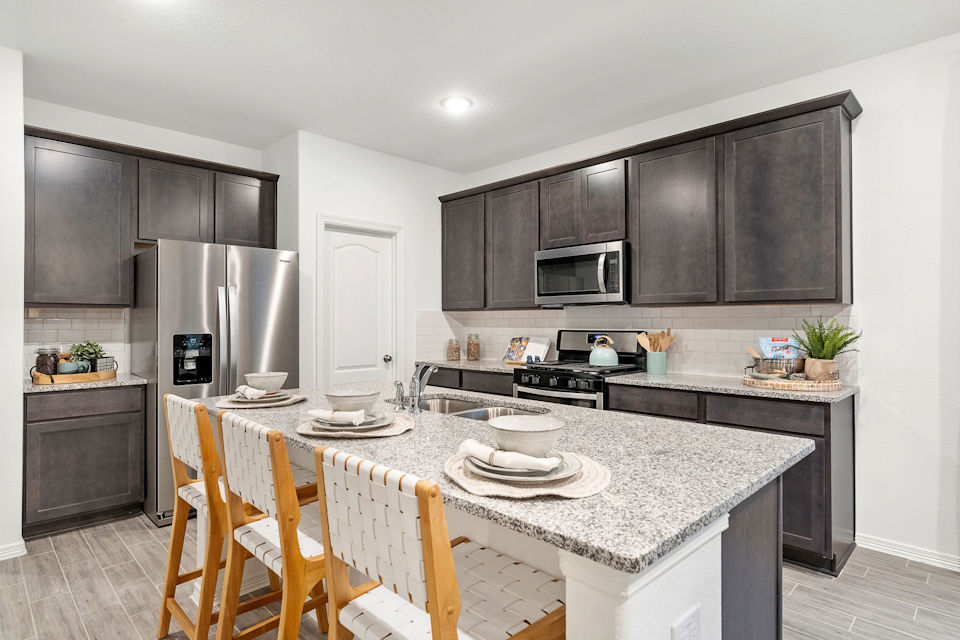 A kitchen with a table and chairs.
