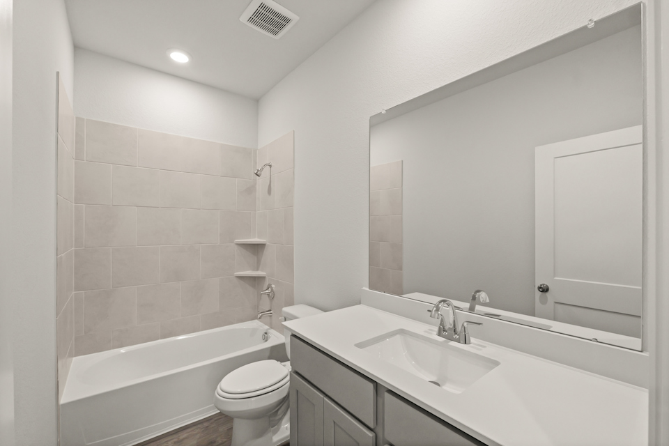 A bathroom with a tub sink and toilet.
