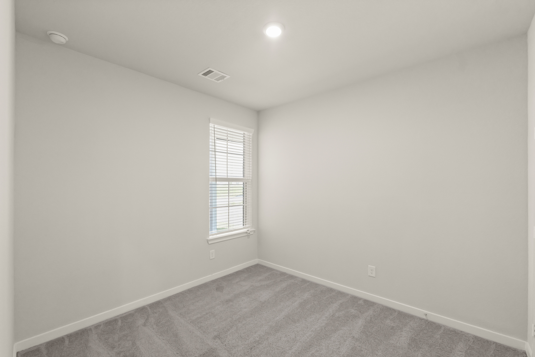 A room with a carpet and a window.