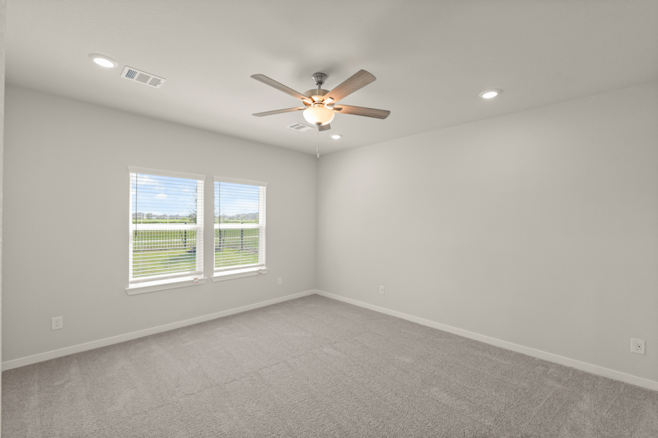 A room with a ceiling fan and a window.