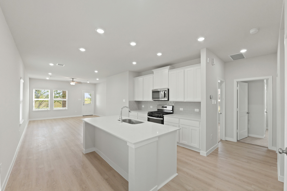 A kitchen with white cabinets.