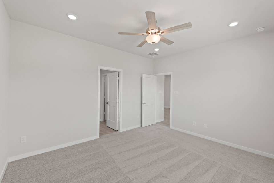 A room with a ceiling fan and a door.