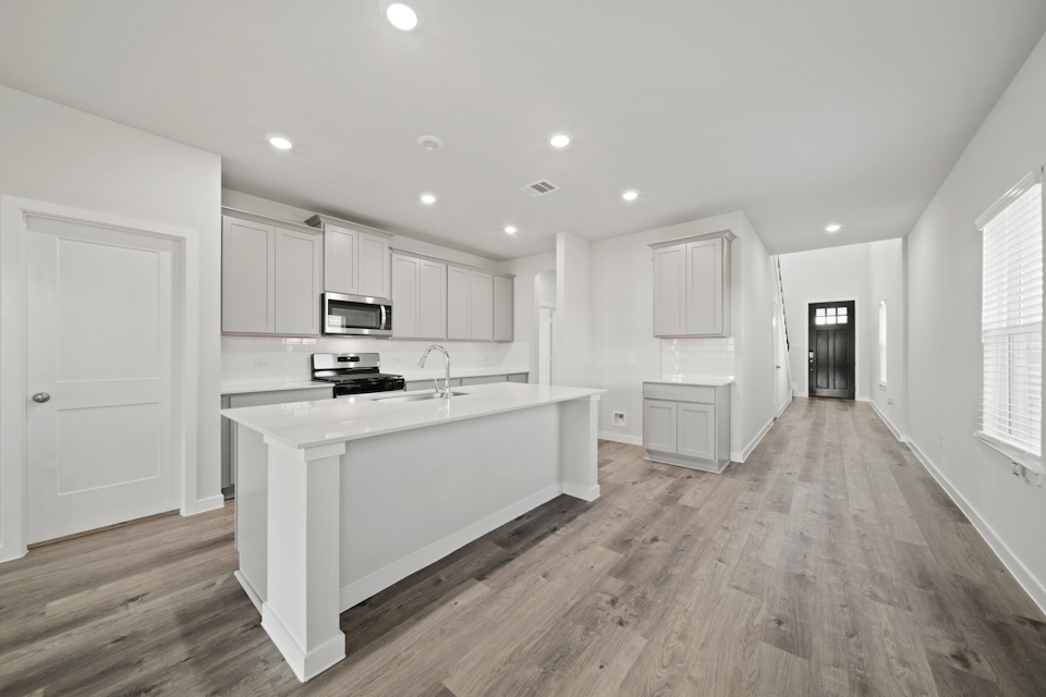 A kitchen with white cabinets.