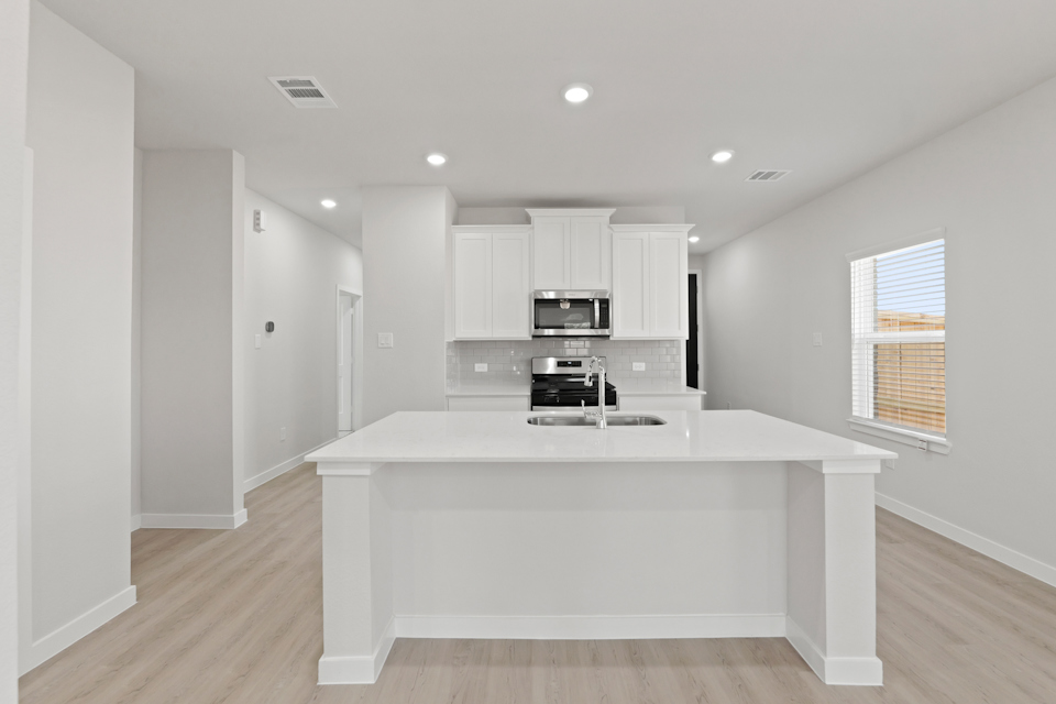 A kitchen with white cabinets.