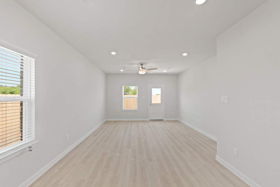 A room with a wood floor and a ceiling fan.