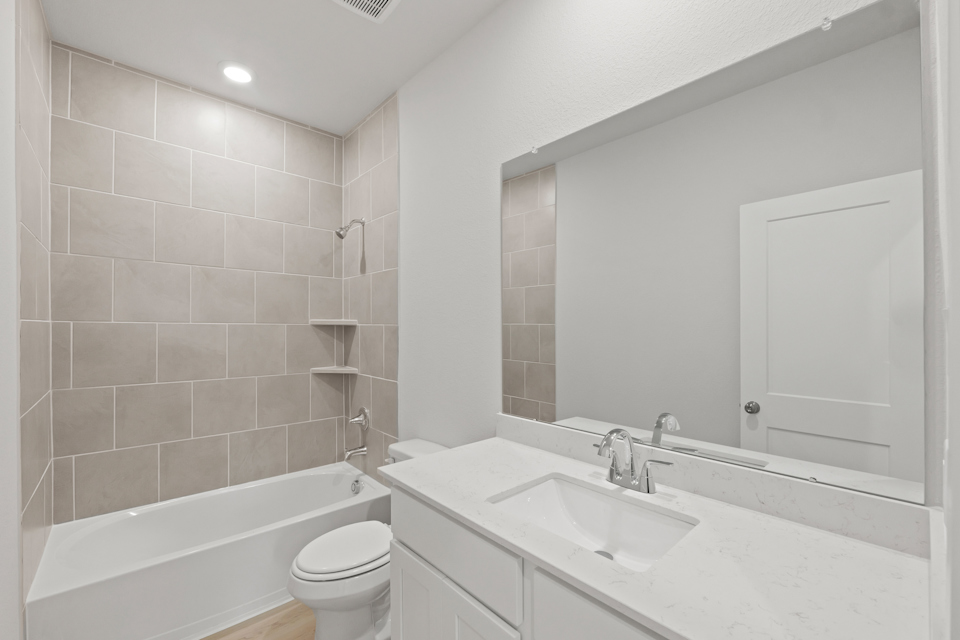 A bathroom with a tub sink and toilet.