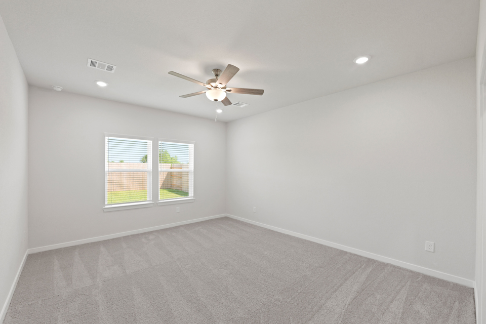 A room with a ceiling fan and a window.