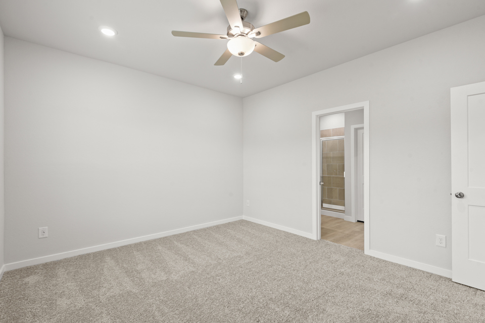 A room with a ceiling fan and a door.