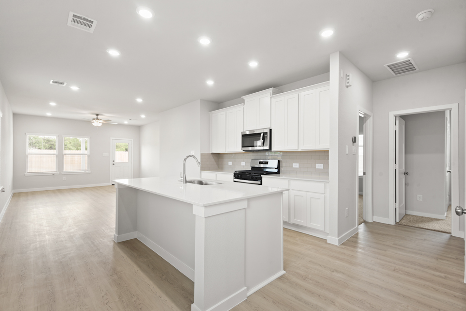 A kitchen with white cabinets.