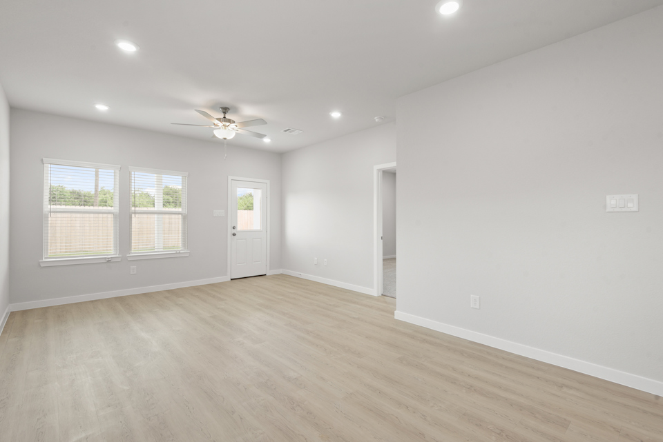 A room with a wood floor and a ceiling fan.