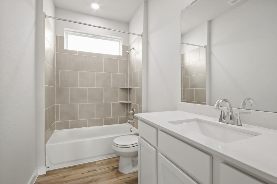 A bathroom with a tub sink and toilet.