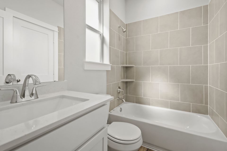 A bathroom with a tub sink and toilet.