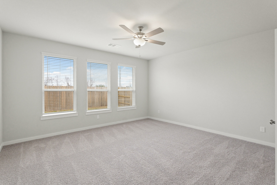 A room with a ceiling fan and a window.