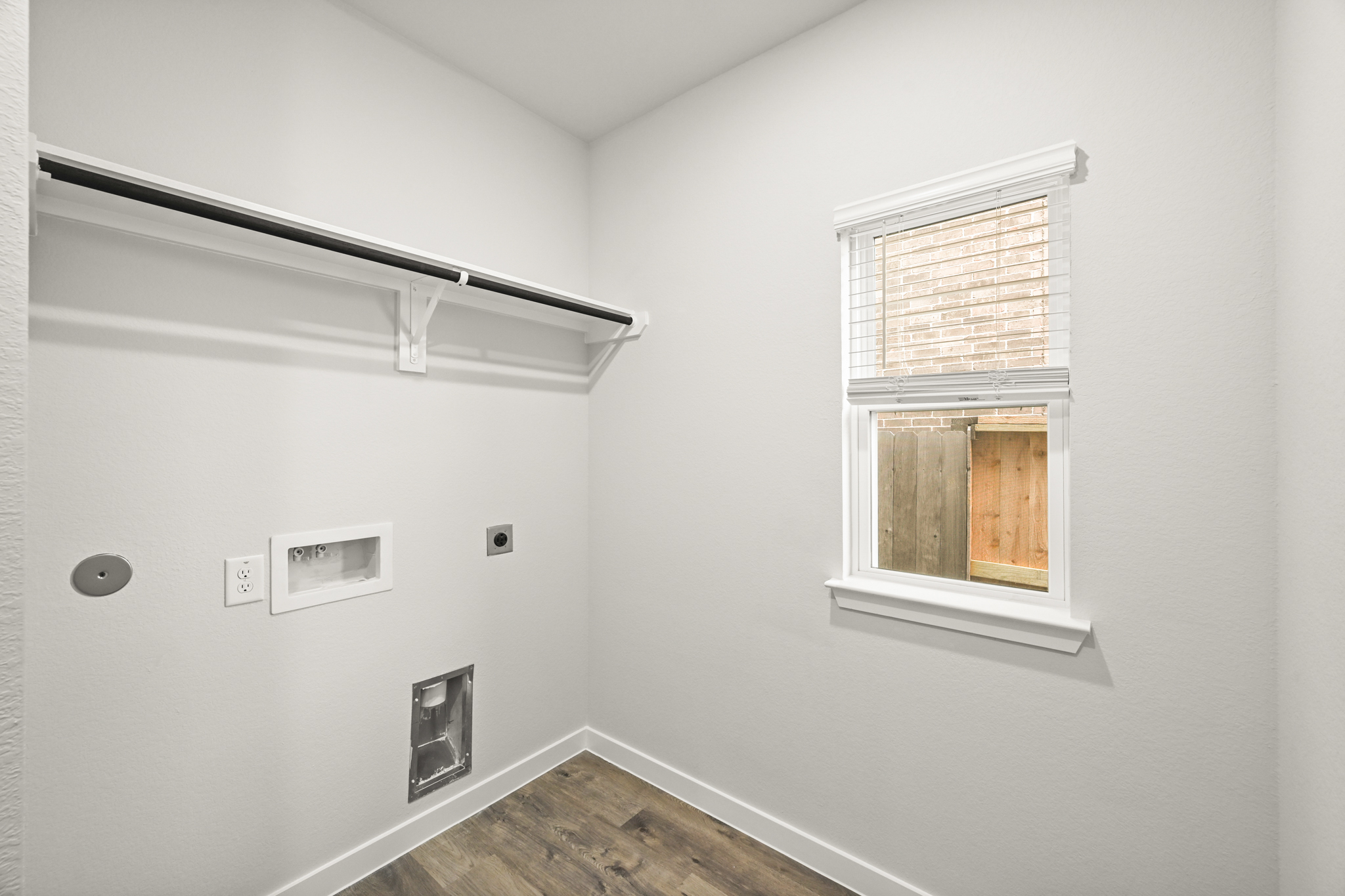 A room with a window and a wood floor.