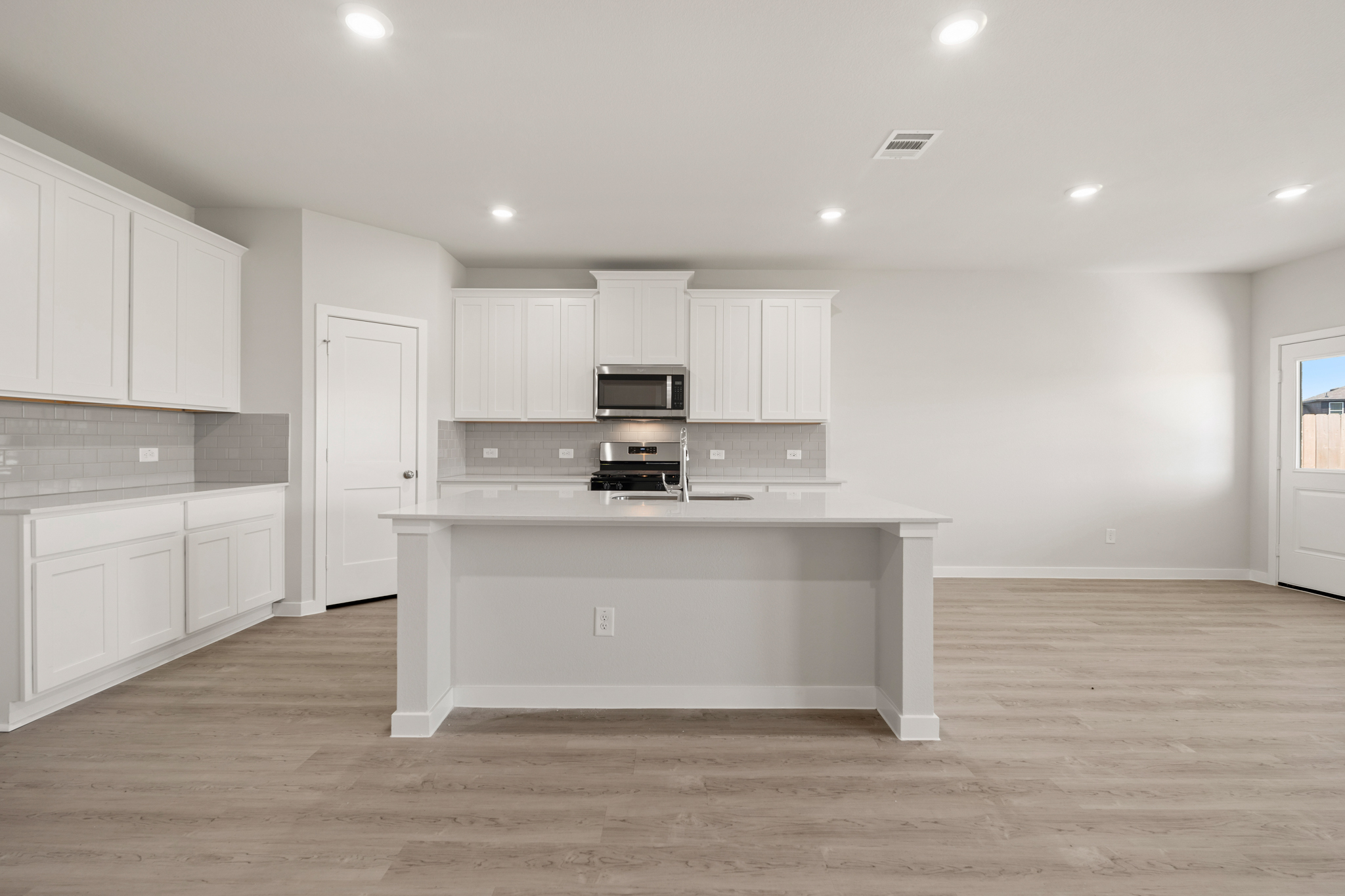 A kitchen with white cabinets.