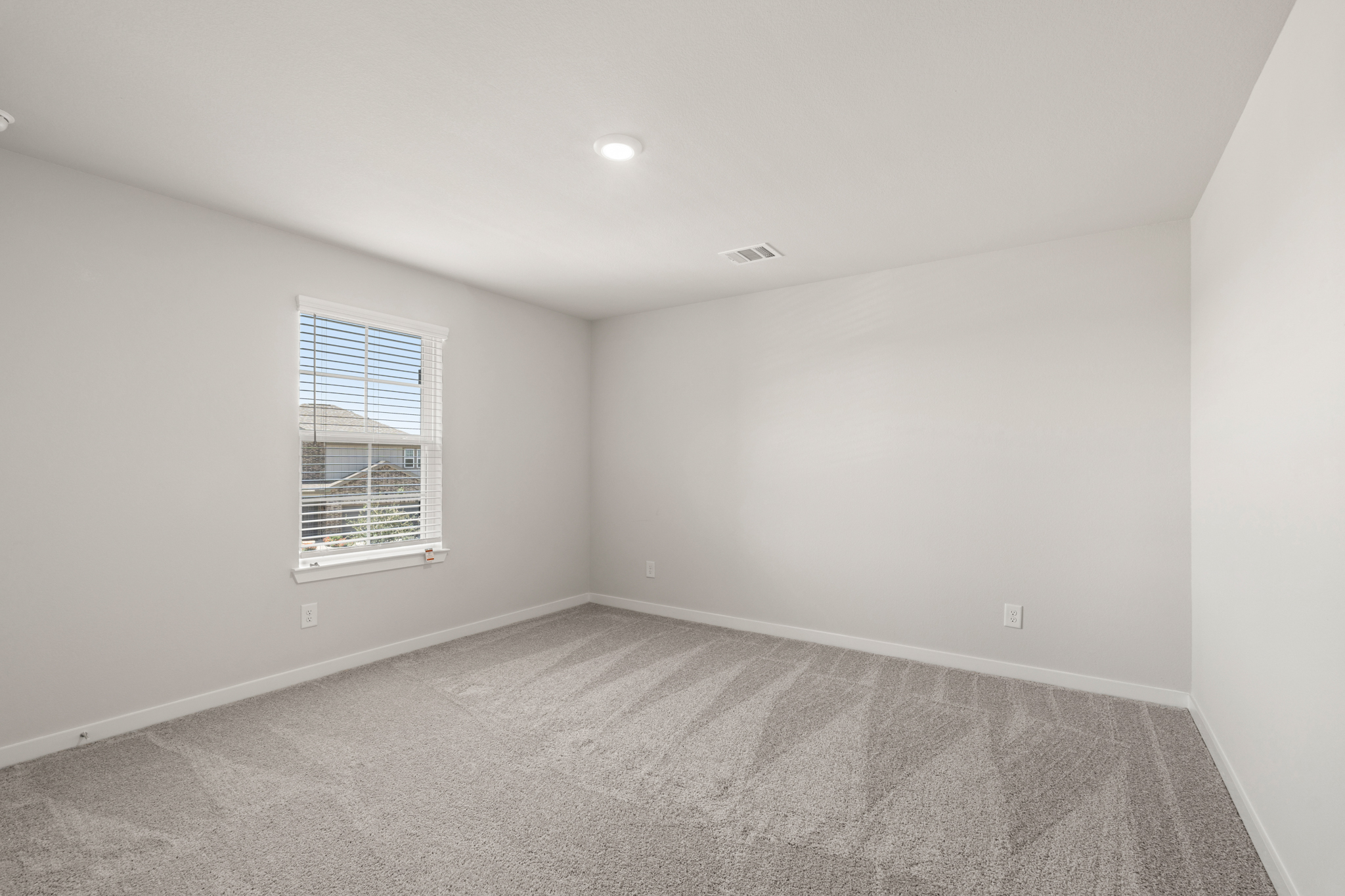 A room with a window and a carpet.