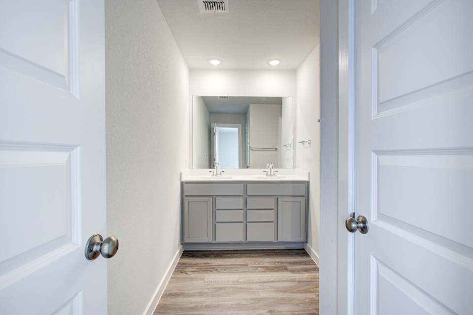 A bathroom with white cabinets.