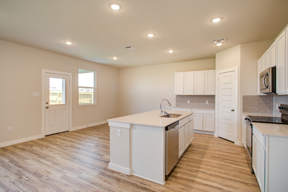 A kitchen with white cabinets.