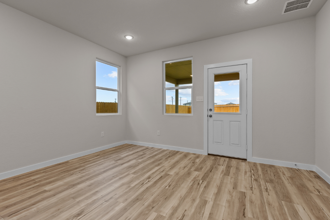 A room with a wood floor and a white door with a window.