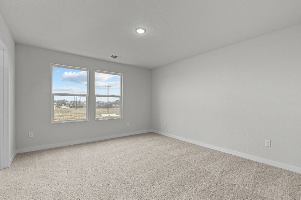 A room with a window and a painting on the wall.