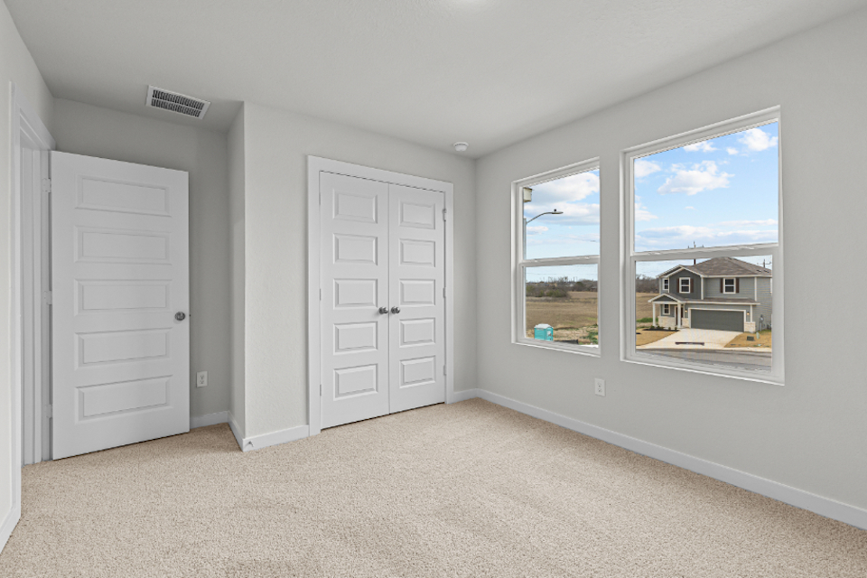 A room with white doors and a window with a view of the ocean.