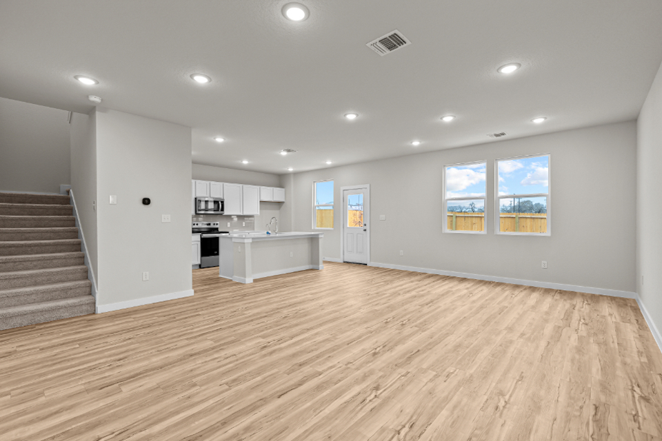 A large kitchen with a wood floor.