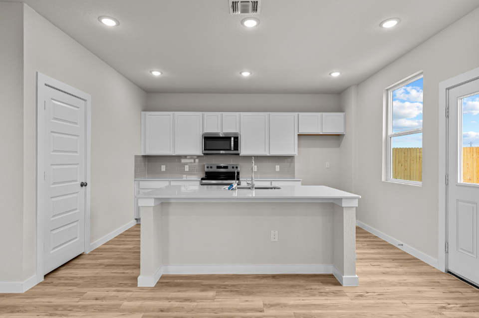 A kitchen with white cabinets.