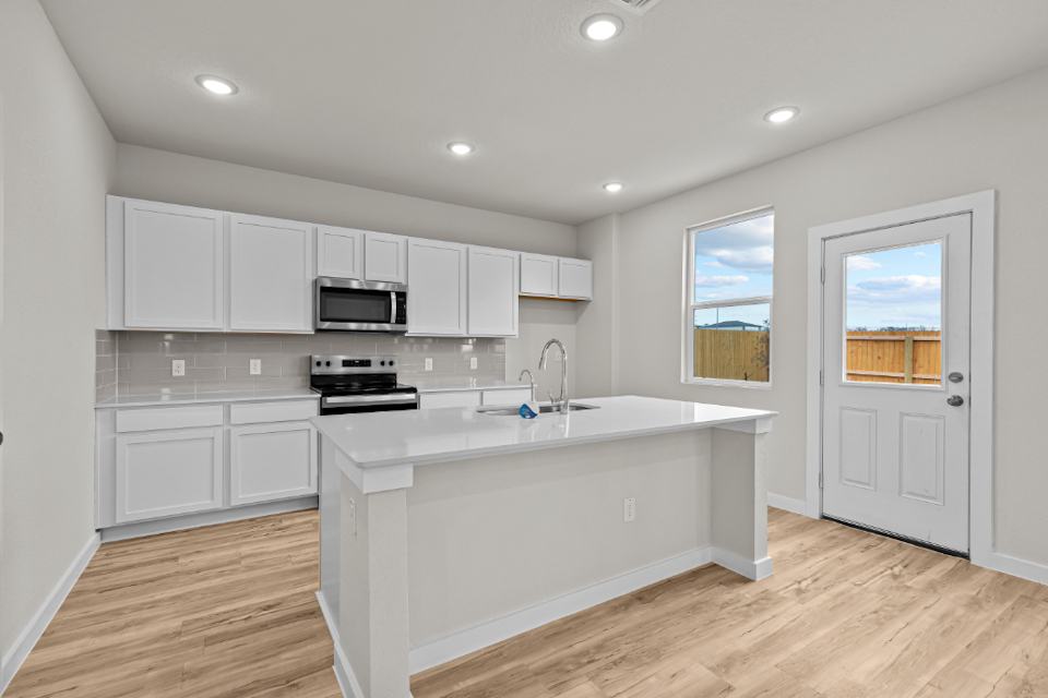 A kitchen with white cabinets.