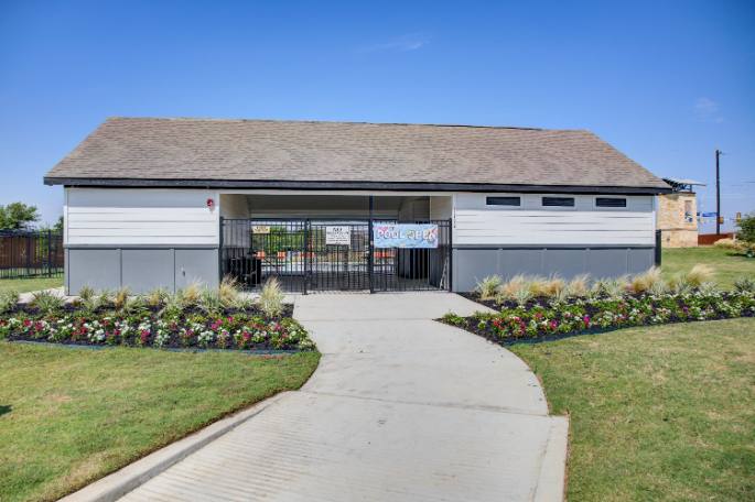 A building with a gate and flowers.