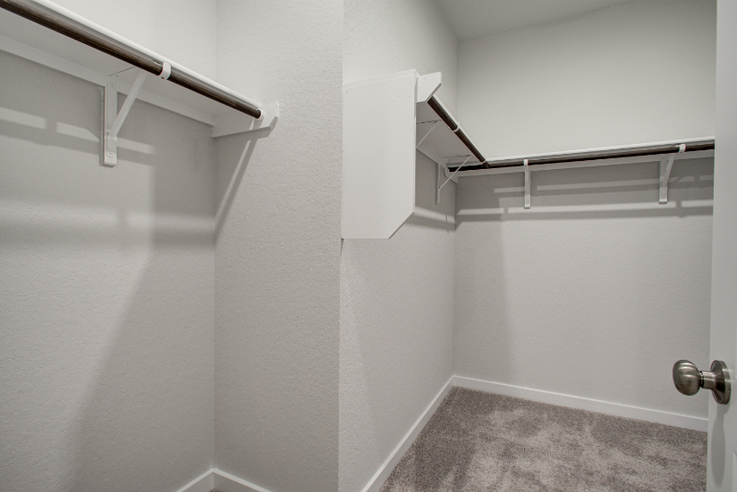 A white wall with a metal bar.