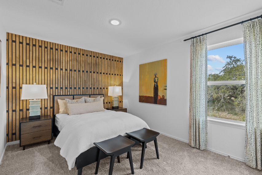 A bedroom with a bed and a table.