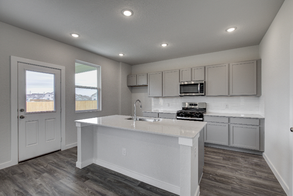 A kitchen with white cabinets.
