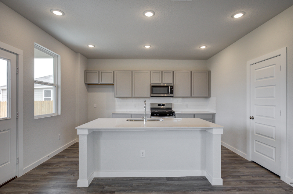 A kitchen with white cabinets.