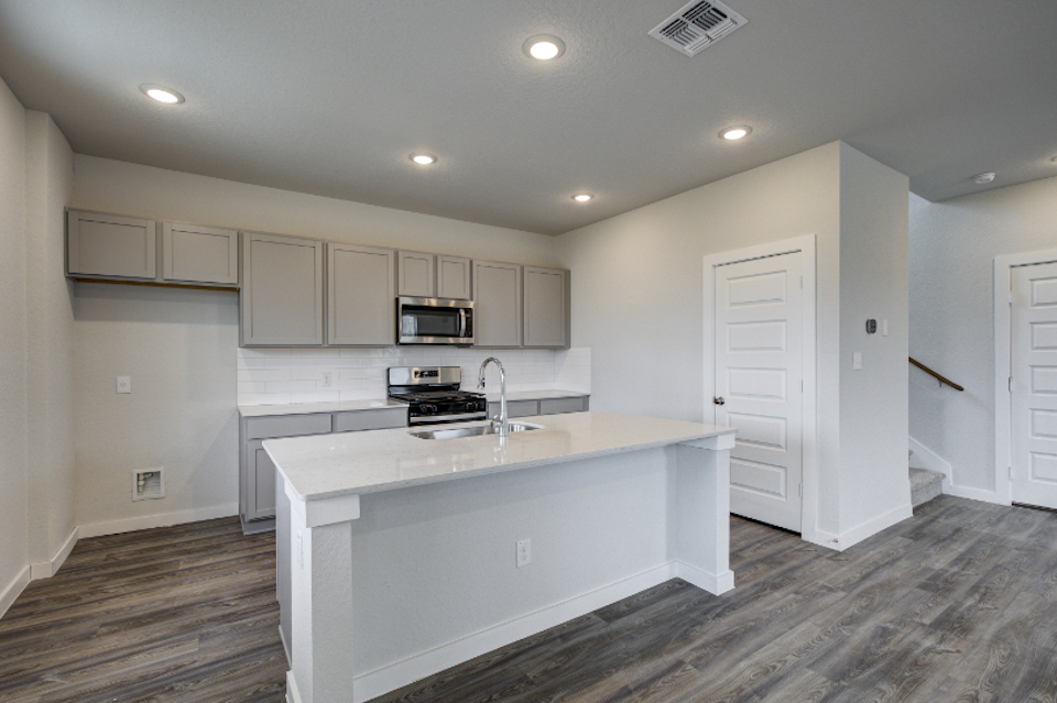A kitchen with white cabinets.