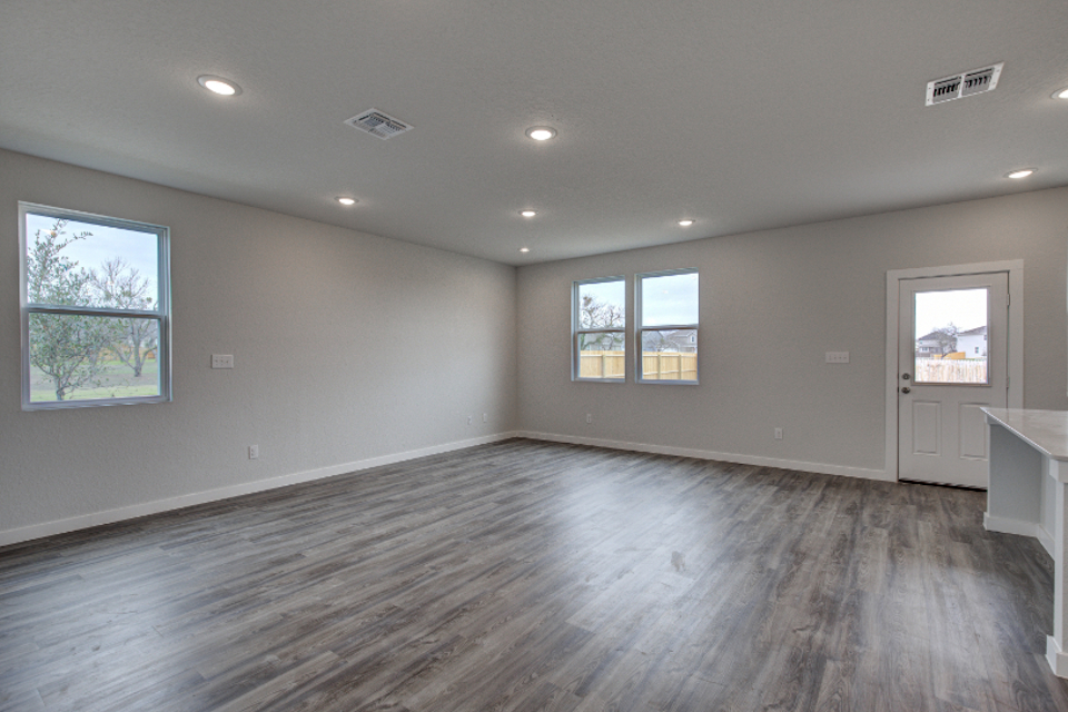 A room with windows and a wood floor.