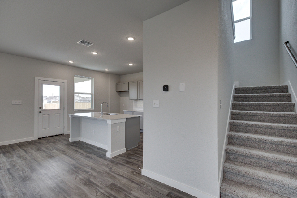 A room with a staircase and a counter.